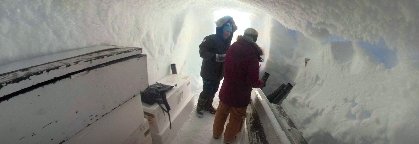 Forskarane Anne-Katrine Faber og Sonja Wahl, ved Universitetet og Bjerknessenteret, har måtte ty til ei hole under isen for å arbeide med og oppbevare snøprøvane frå isen. (Foto: EastGRIP)